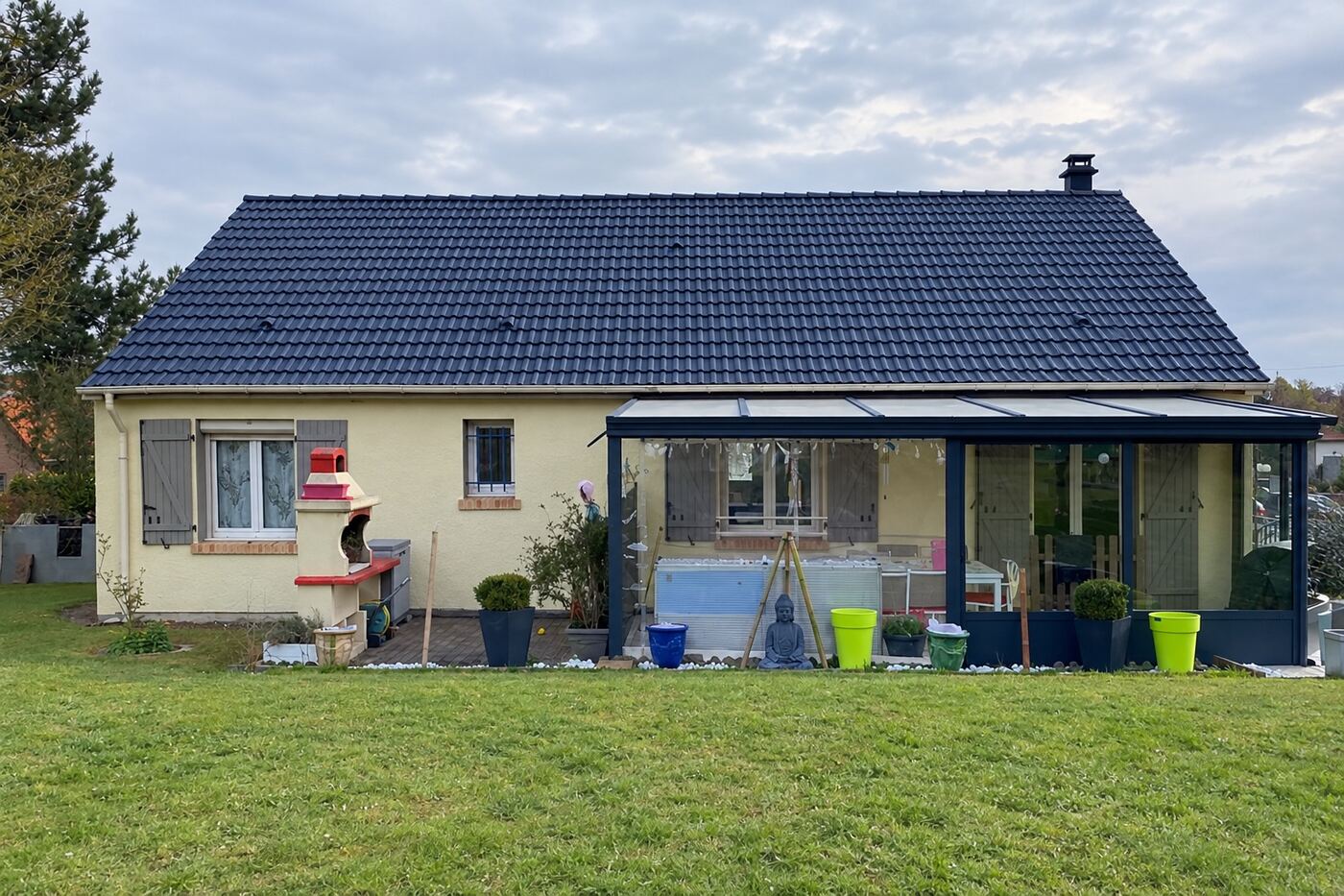 Après rénovation : maison avec véranda : nouvelle teinte ardoise sur toute la toiture